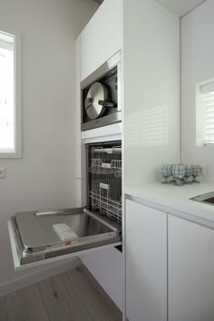 an open microwave oven sitting inside of a kitchen