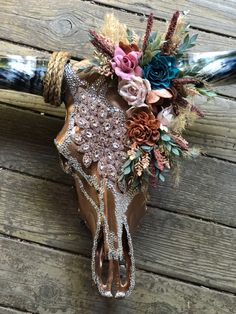 a cow skull decorated with flowers and beads