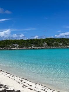 an empty beach with clear blue water and white sand