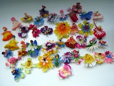 many different colored flowers on a white surface with one being cut out and the other is made from paper