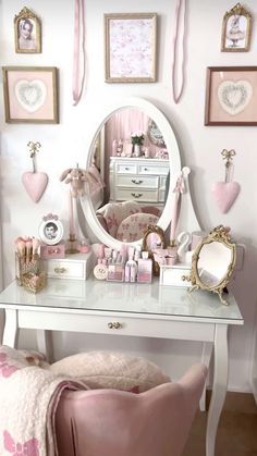 a white desk topped with a mirror next to a pink chair