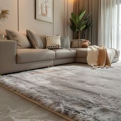 a living room filled with furniture and a large rug on top of a carpeted floor