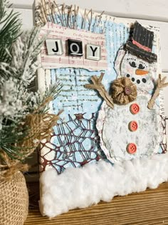 a snowman made out of buttons sitting on top of a wooden table