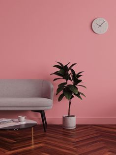 a living room with a couch, coffee table and clock on the wall