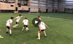 a group of young men kicking around a soccer ball on top of a green field