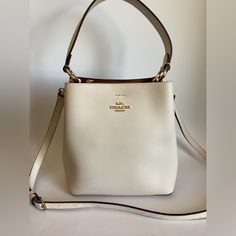 Coach Small Town Bucket Bag Leather Crossbody 1011 In Chalk White $350. Polished Pebble Leather Center Zip Compartment Snap Closure Handle With 6 3/4″ Drop Detachable Strap With 22″ Drop For Shoulder Or Crossbody Wear 8 1/2″ (L) X 8 3/4″ (H) X 4″ (W) Luxury Cream Bucket Bag, Luxury Cream Crossbody Bucket Bag, Luxury Cream Bucket Bag With Detachable Handle, Luxury Cream Bucket Bag With Removable Pouch, Luxury Cream Bucket Shoulder Bag, Luxury Cream Bucket Bag With Gold-tone Hardware, Everyday Luxury Bags With Gold-tone Hardware, High-end Formal Bucket Bag With Detachable Strap, Luxury White Evening Bucket Bag