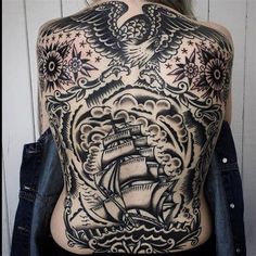 the back of a woman's body with an eagle and ship tattoo on it