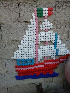 a building made out of legos with a sailboat on it's side