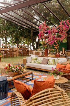 a room filled with lots of furniture covered in plants and hanging potted plants on the ceiling