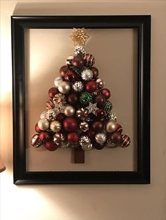 a christmas tree made out of ornaments in a frame