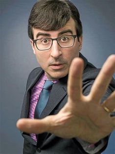 a man in a suit and tie making the vulcan sign with his hand while wearing glasses