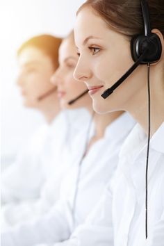 three women wearing headsets are sitting in line