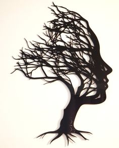 the silhouette of a woman's head is made out of branches