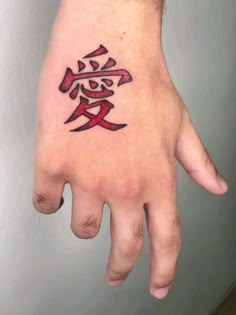 a person's hand with a tattoo on it and the word love written in red ink