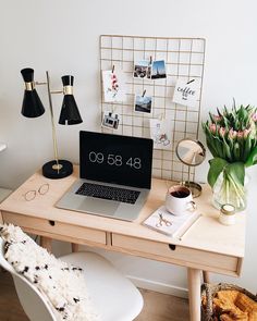 a laptop computer sitting on top of a wooden desk next to a cup of coffee