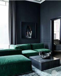 a living room with black walls and green furniture