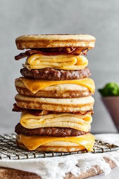 a stack of pancakes topped with cheese and bacon