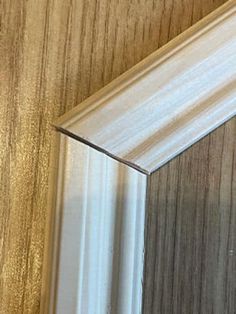 a close up of a mirror with wood grained walls and white trim on it