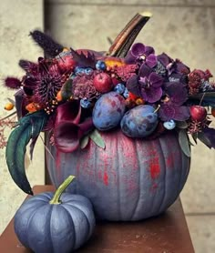 a painted pumpkin with flowers and leaves in it