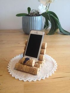 a cell phone sitting on top of corks in front of a potted plant