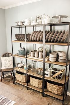 a room filled with lots of plates and bowls on top of a wooden shelf next to a