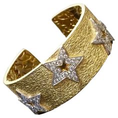 DeKara Design Collection Metal- 18K Yellow Gold, .750, 96 Grams. Stones- 100 Round Diamonds G Color VS1 Clarity 5.03 Carats. Measurements- 1 Inch Wide, 4.22 MM Thick, Stars are 21 MM x 21 MM. Entirely handmade heavy 18K Yellow Gold Diamond Star Cuff Bracelet. This bracelet has 5 white gold stars that have 20 pave diamonds on each start that have been hand assembled onto the bracelet itself. The gallery inside of the bracelet has all separately made with starts and other scroll work that gives th Designer Yellow Gold Cuff Bracelet, Luxury Cuff Bracelet With 17 Jewels For Anniversary, Yellow Gold Cuff Jewelry For Anniversary, Luxury Cuff Bracelets For Anniversary, Luxury Star-shaped Formal Jewelry, Designer Cuff Bracelet For Anniversary, Luxury Hallmarked Cuff Bracelet For Anniversary, Luxury Star-shaped Jewelry For Formal Events, Designer Cuff Jewelry For Anniversary