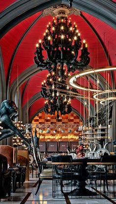 a large chandelier hanging from the ceiling in a room with tables and chairs