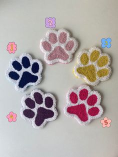 four different colored paw prints on a white surface