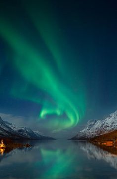 an image of the aurora bore in the night sky over water with mountains and snow