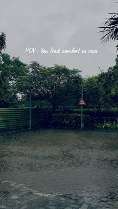 an empty parking lot in front of some trees with the words pov you find comfort in rain