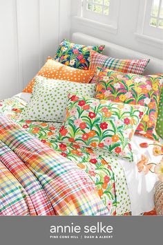 an image of a bed with colorful sheets and pillows