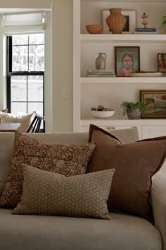 a living room filled with lots of furniture and pillows