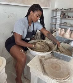 a woman working on pottery in a studio