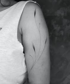 a black and white photo of a woman's arm with an arrow tattoo on it