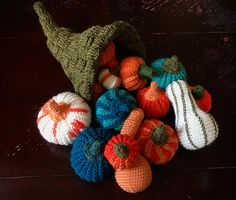 crocheted pumpkins and gourds are on the table with their tops turned upside down