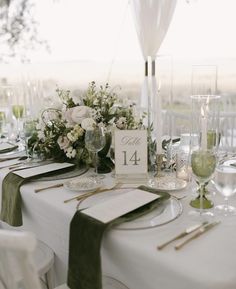 the table is set with place cards and wine glasses