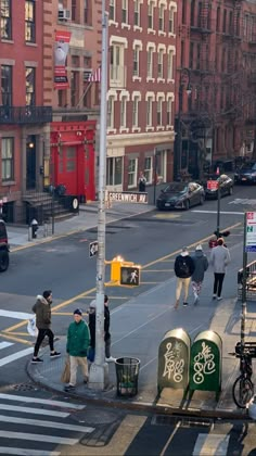 people crossing the street at an intersection in a city