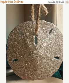 a round ornament hanging from a rope on top of a window sill