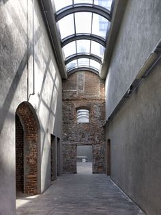 an empty hallway with arched windows and brick walls