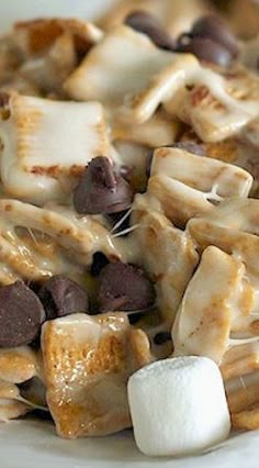 a white plate topped with pasta covered in cheese and marshmallows next to chocolate chips