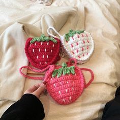 three crocheted strawberries sitting on top of a bed