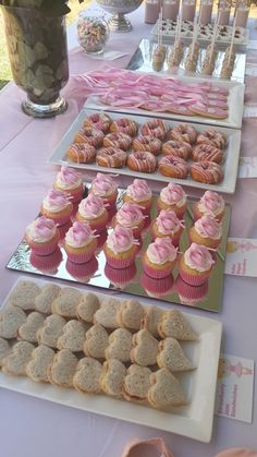 a table topped with lots of cupcakes and cookies