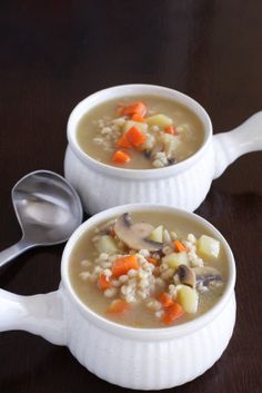 two white bowls filled with soup on top of a table