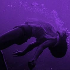 a man dives into the water with his feet in the air as he swims