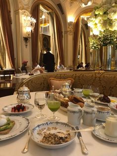 the table is set with many plates and bowls of food on it, along with silverware