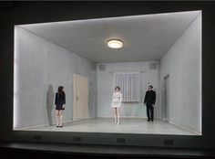 three people are standing in an empty room