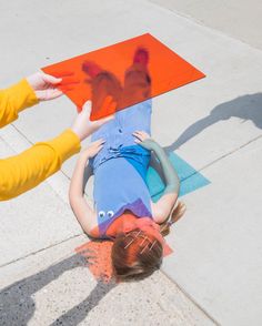 two children are playing on the sidewalk with their hands