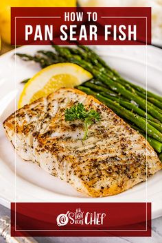 a white plate topped with fish and asparagus next to lemon wedges on a table