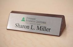 a business name plate sitting on top of a wooden table