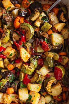 roasted vegetables in a casserole dish with a spoon